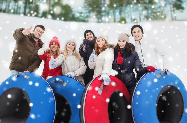 Grupo de amigos sonrientes con tubos de nieve —  Fotos de Stock