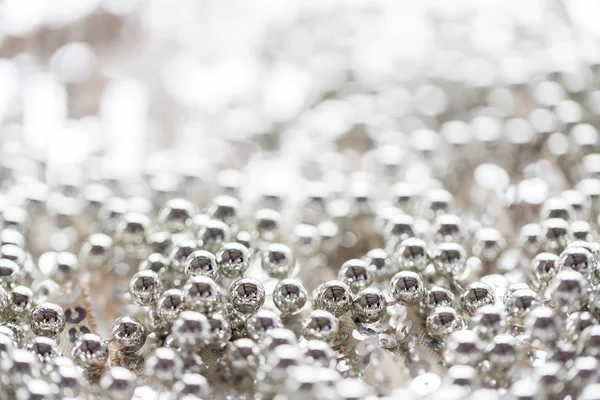 Close up of silver beads on shiny sequined texture — Zdjęcie stockowe