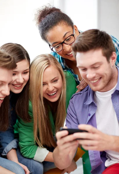 Grupo de estudantes felizes com smartphone na escola — Fotografia de Stock