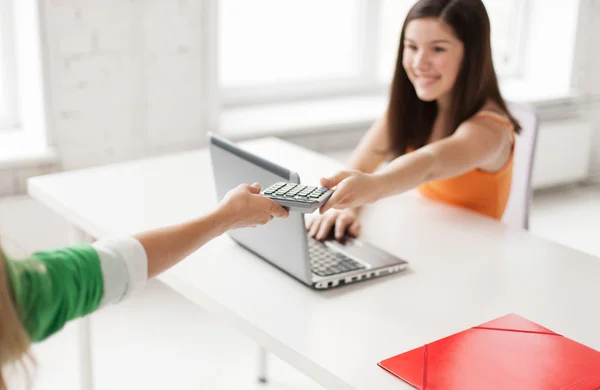 Students with laptop sharing calculator at school — Stock fotografie