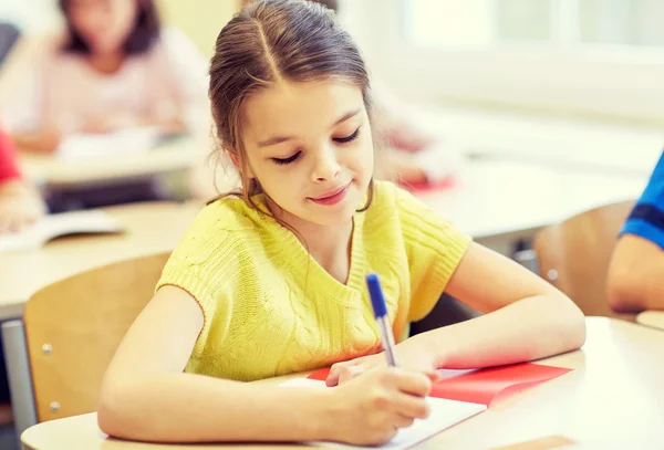 Group of school kids writing test in classroom Stock Photo