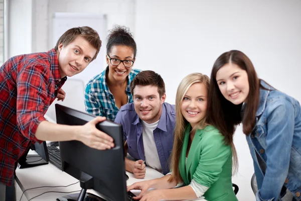 Счастливые старшеклассники в компьютерном классе — стоковое фото