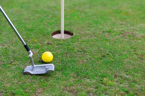 Close up van club en bal in de buurt van gat op golf veld — Stockfoto