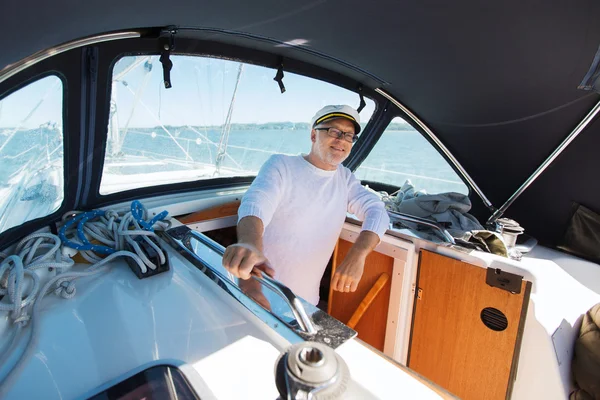 Homem sênior feliz em barco ou iate navegando no mar — Fotografia de Stock