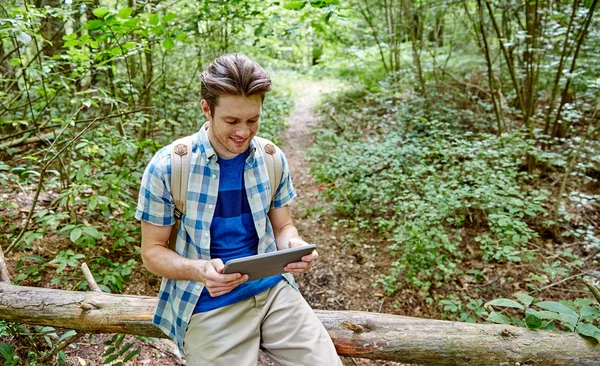 Szczęśliwy człowiek z plecaka i tablet pc w lesie — Zdjęcie stockowe
