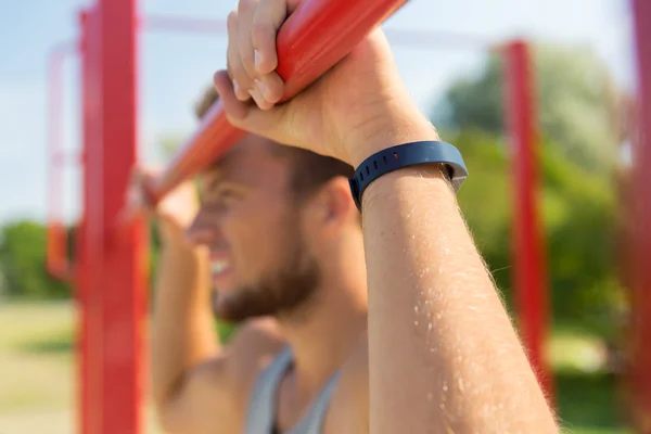 Jongeman die buiten op de horizontale balk traint — Stockfoto