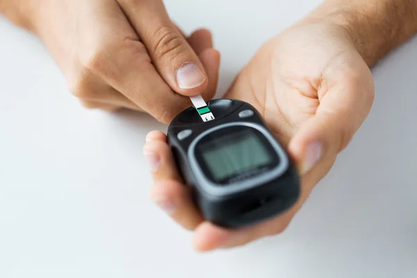 Close up of man checking blood sugar by glucometer — Stock Photo, Image