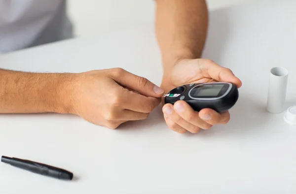 Close up of man checking blood sugar by glucometer — Stock Photo, Image