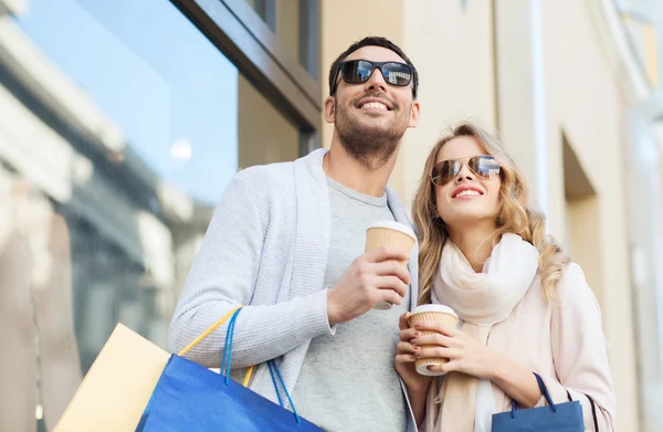 Lyckliga par med kassar och kaffe i city — Stockfoto