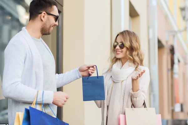 Casal feliz com sacos de compras na cidade — Fotografia de Stock