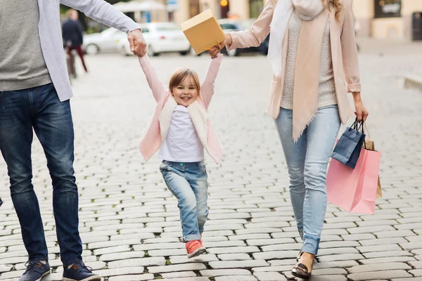Ευτυχισμένη οικογένεια με παιδί και τσάντες για ψώνια στην πόλη — Φωτογραφία Αρχείου