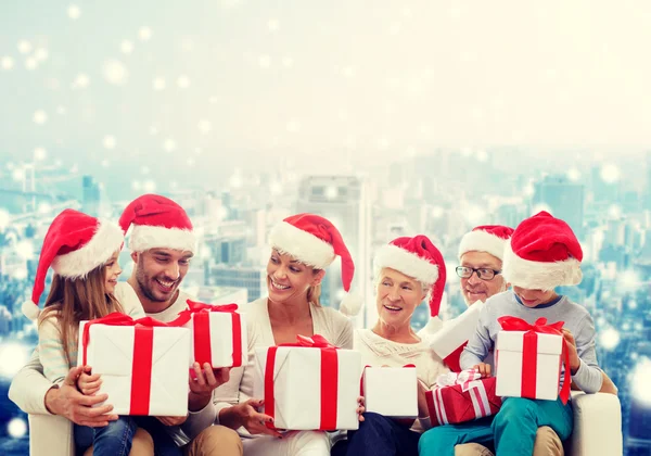 Gelukkige familie in santa helper hoeden met geschenkdozen — Stockfoto