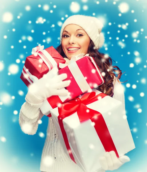 Mujer en suéter y sombrero con muchas cajas de regalo — Foto de Stock