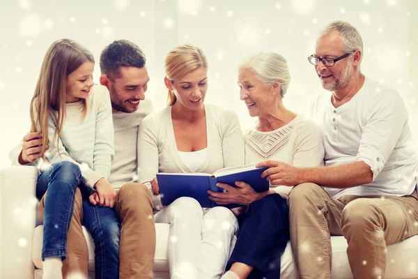 Família feliz com livro ou álbum de fotos em casa — Fotografia de Stock