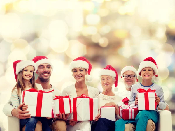 Família feliz em santa helper chapéus com caixas de presente — Fotografia de Stock