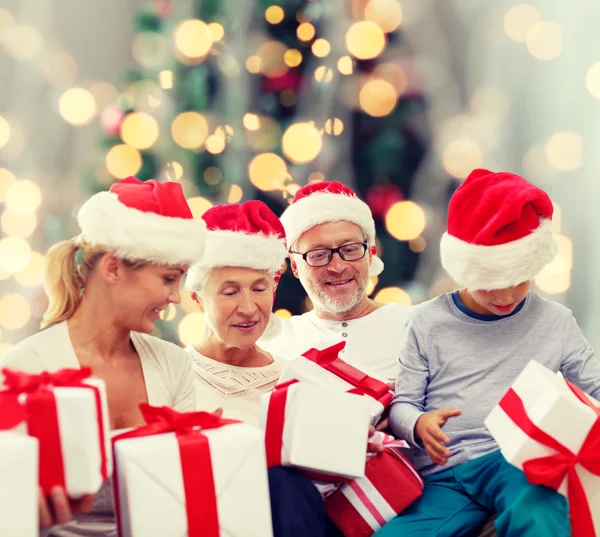 Família feliz em santa helper chapéus com caixas de presente — Fotografia de Stock