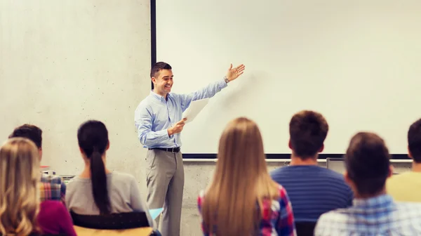 Group of students and smiling teacher with notepad — Stock Photo, Image
