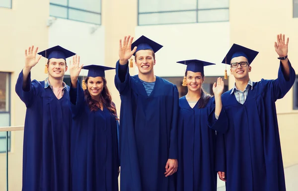 Grup gülümseyen öğrenci mortarboards içinde — Stok fotoğraf