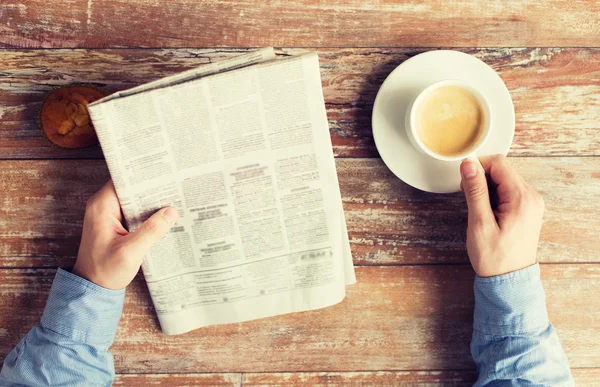 Close up of male hands with newspaper and coffee — Stock Photo, Image