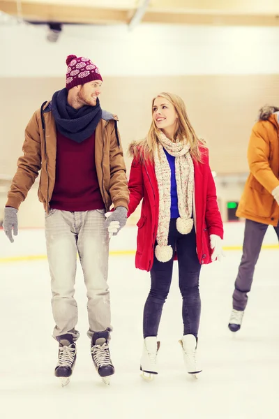 Feliz pareja cogida de la mano en pista de patinaje — Foto de Stock