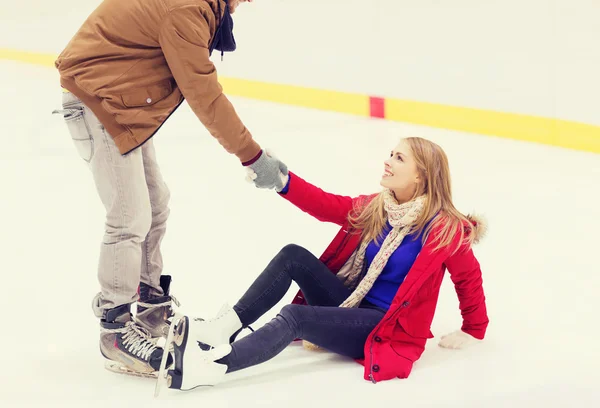 Homme aidant les femmes à se lever sur la patinoire — Photo