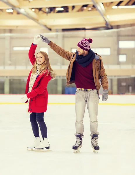 Feliz pareja cogida de la mano en pista de patinaje — Foto de Stock