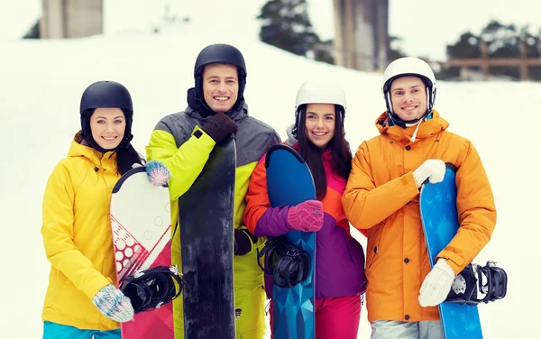 Amigos felices en cascos con snowboards —  Fotos de Stock