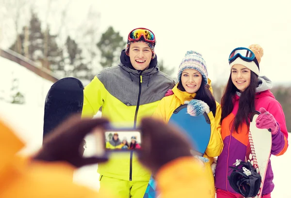 Amigos felices con tablas de snowboard y smartphone — Foto de Stock