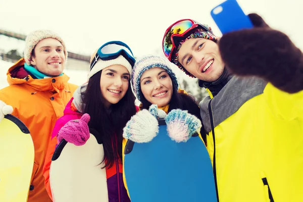 Teman bahagia dengan papan salju dan smartphone — Stok Foto