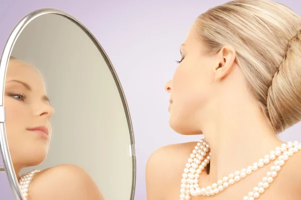 Hermosa mujer con collar de perlas y espejo — Foto de Stock