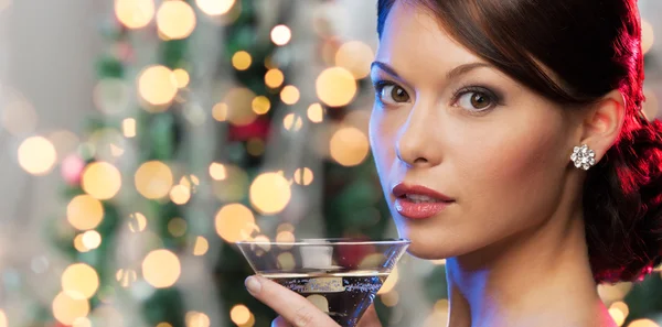 Mulher com coquetel sobre luzes de árvore de natal — Fotografia de Stock