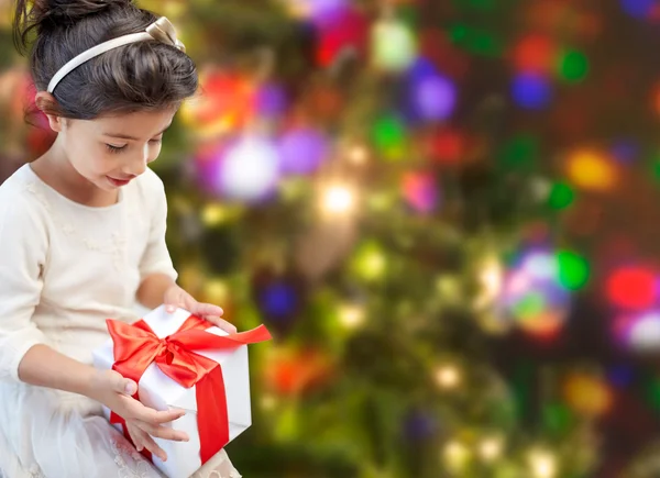 Niña feliz con presente sobre las luces —  Fotos de Stock