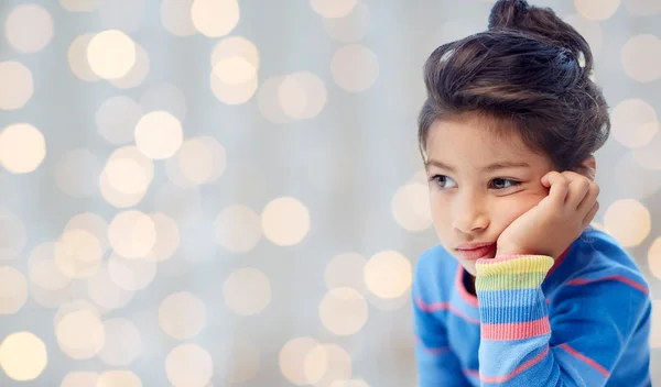 Triste petite fille sur fond de lumières vacances — Photo