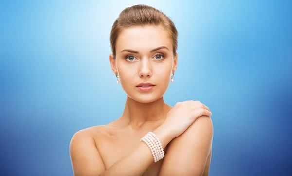 Hermosa mujer con pendientes de perlas y pulsera — Foto de Stock