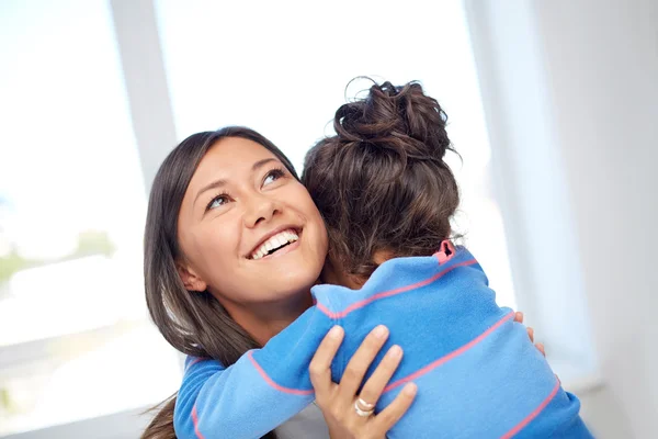 happy mother and daughter hugging at home