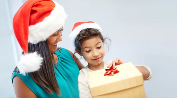 幸福的母亲和孩子在圣诞老人的帽子与礼品盒 — 图库照片