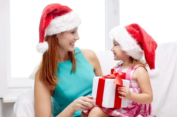 幸福的母亲和孩子在圣诞老人的帽子与礼品盒 — 图库照片