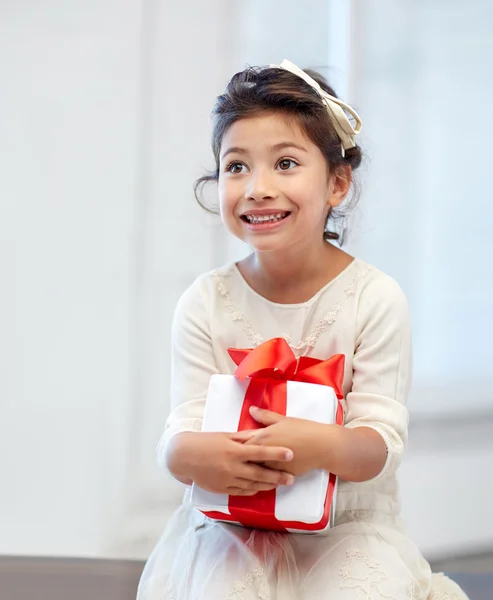 Menina feliz com caixa de presente em casa — Fotografia de Stock