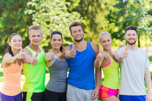 Grupo de amigos deportistas felices mostrando pulgares hacia arriba — Foto de Stock