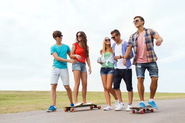 Felizes amigos adolescentes com longboards ao ar livre — Fotografia de Stock