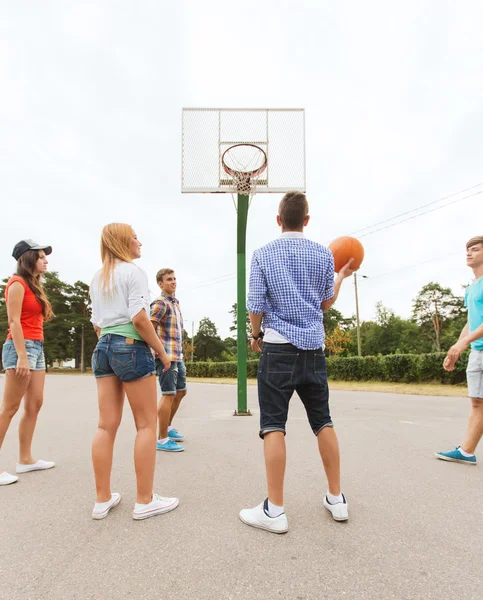 Skupina happy teenagerů hrát basketbal — Stock fotografie