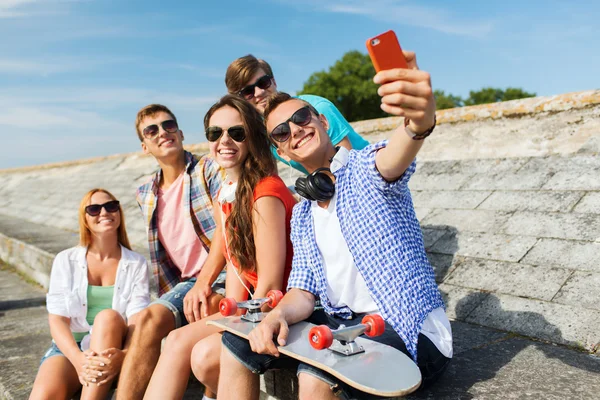 Amigos felices con teléfono inteligente tomando selfie —  Fotos de Stock