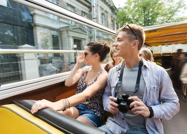 Casal sorridente com câmera viajando de ônibus turístico — Fotografia de Stock