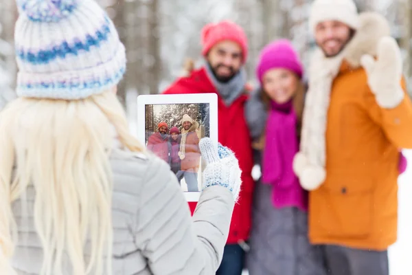 Amigos felizes com tablet pc na floresta de inverno — Fotografia de Stock