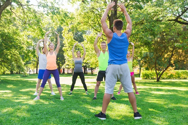 Grupo de amigos o deportistas que hacen ejercicio al aire libre —  Fotos de Stock