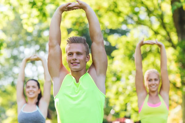 Group of friends or sportsmen exercising outdoors — Stock Photo, Image