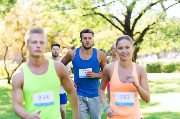 Happ junge Sportler rasen mit Abzeichen-Nummern — Stockfoto