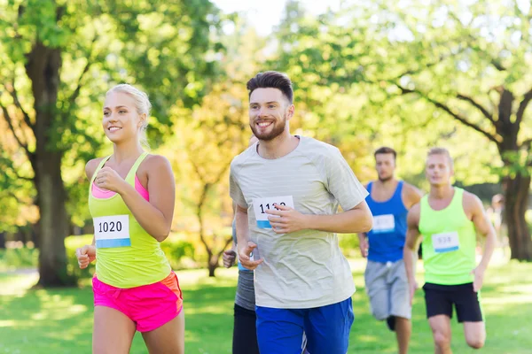 Feliz joven deportistas carreras ingenio insignia números — Foto de Stock