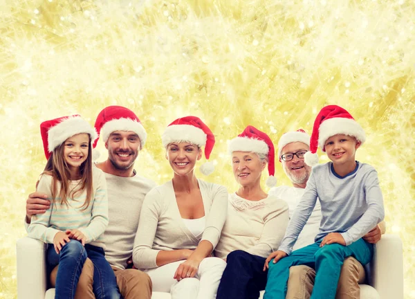 Heureux famille dans santa helper chapeaux assis sur canapé — Photo