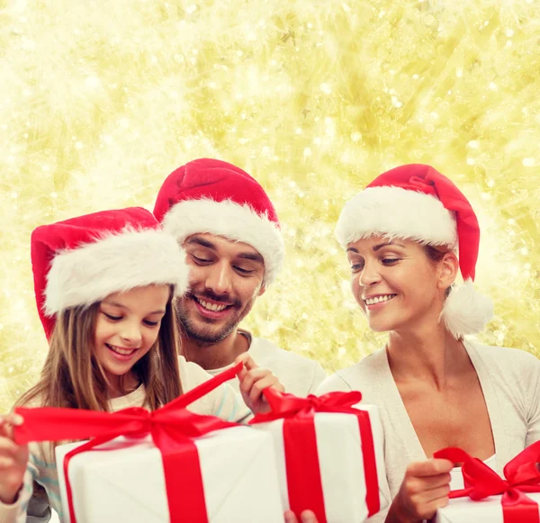 Famiglia felice in cappelli Babbo Natale aiutante con scatole regalo — Foto Stock